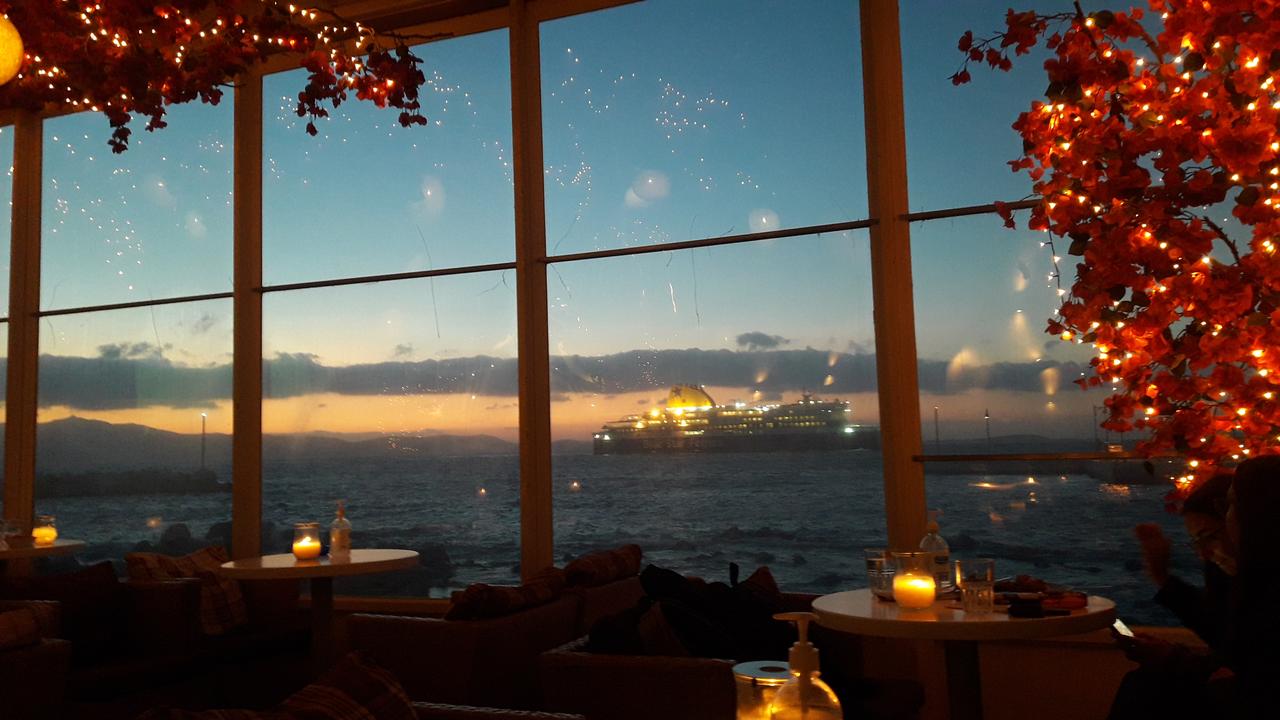 Blick aus einem dekorierten Café-Fenster auf das Meer und eine vorbei fahrende Fähre
